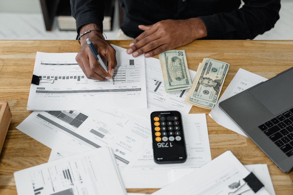 Financial planning documents, calculator, and cash on a desk